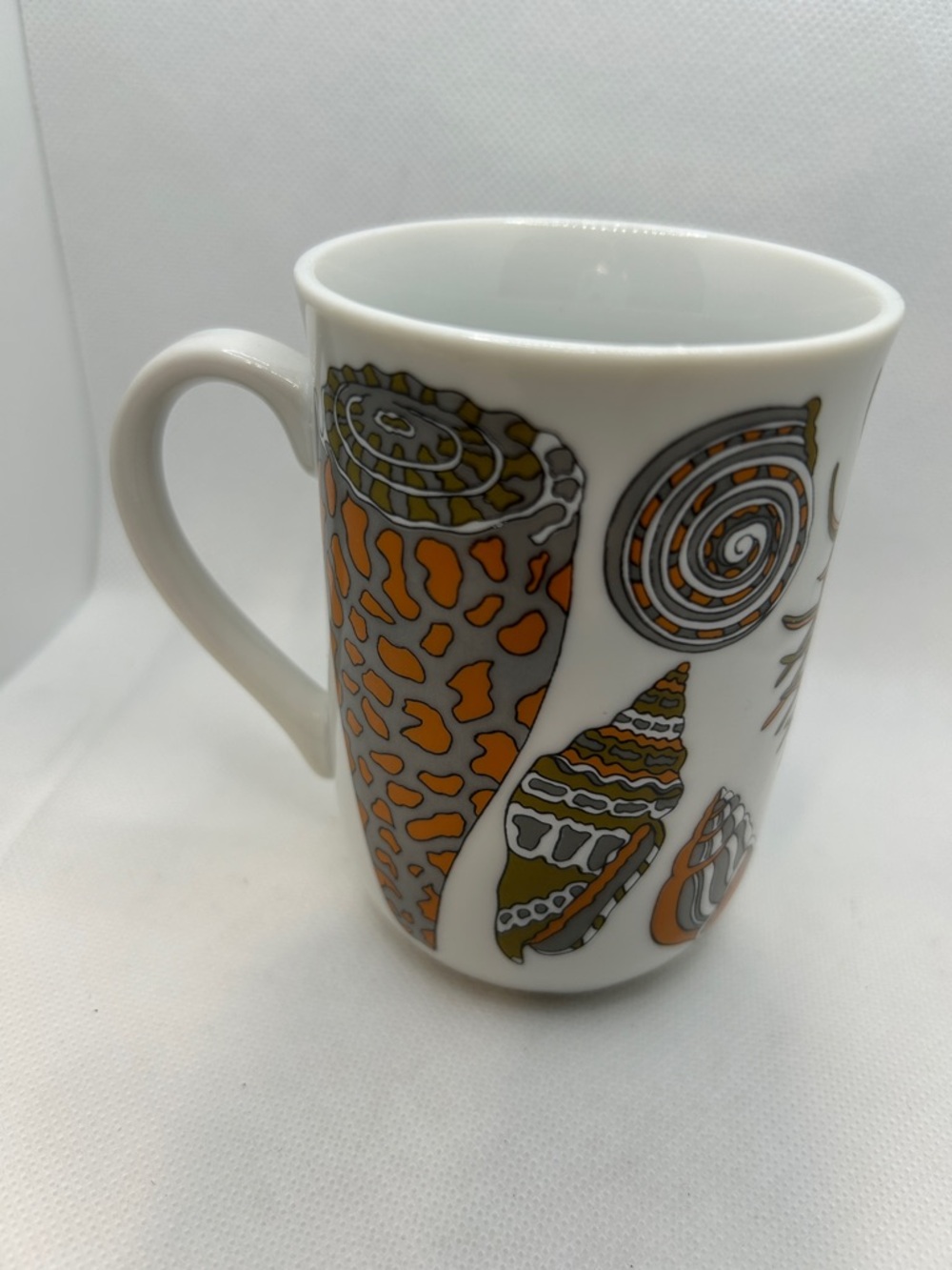 White Ceramic Seashell Mug with Orange and Olive Shell Designs